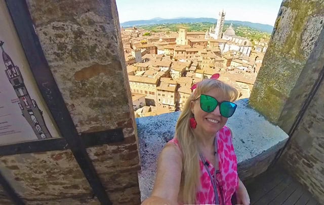 Traveler climbing Torre del Mangia in Siena